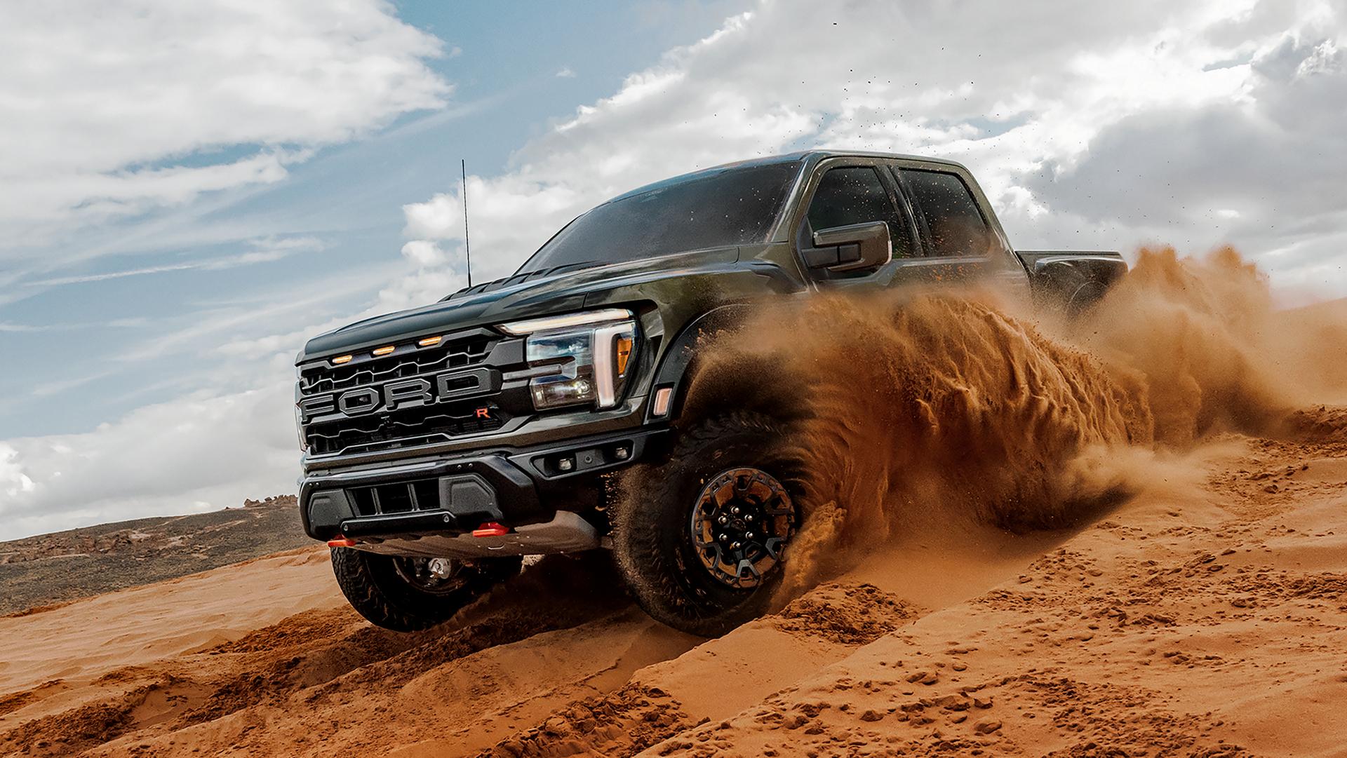 2026 Ford F-150® Raptor® R™ truck kicking up sand while being driven in the desert