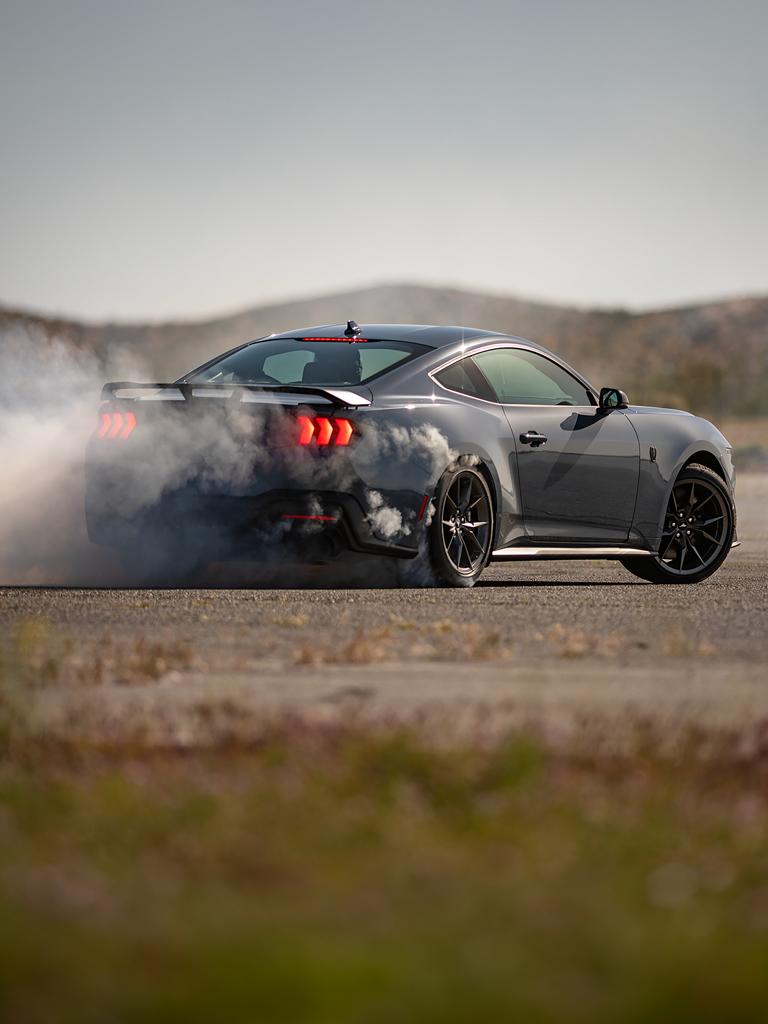 2025 Ford Mustang® Dark Horse® Fastback in Vapour Blue Metallic with a driver performing burnouts on a closed course