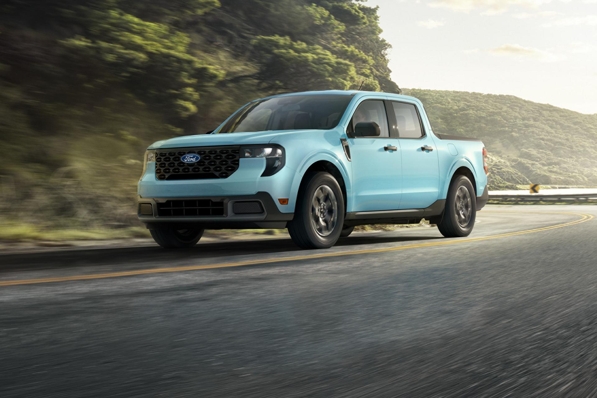 2026 Ford Maverick® pickup driving down a winding highway near a mountain lake