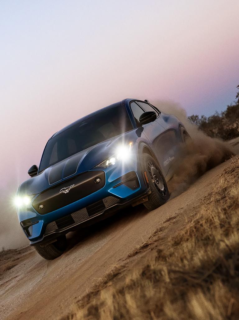 2026 Ford Mustang Mach-E® Rally model on a dirt road with a cloud of dust
